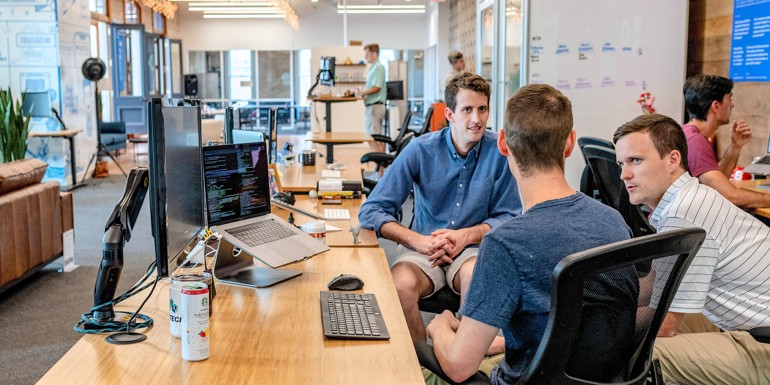 Afslappet forretningsmøde mellem tre yngre mænd